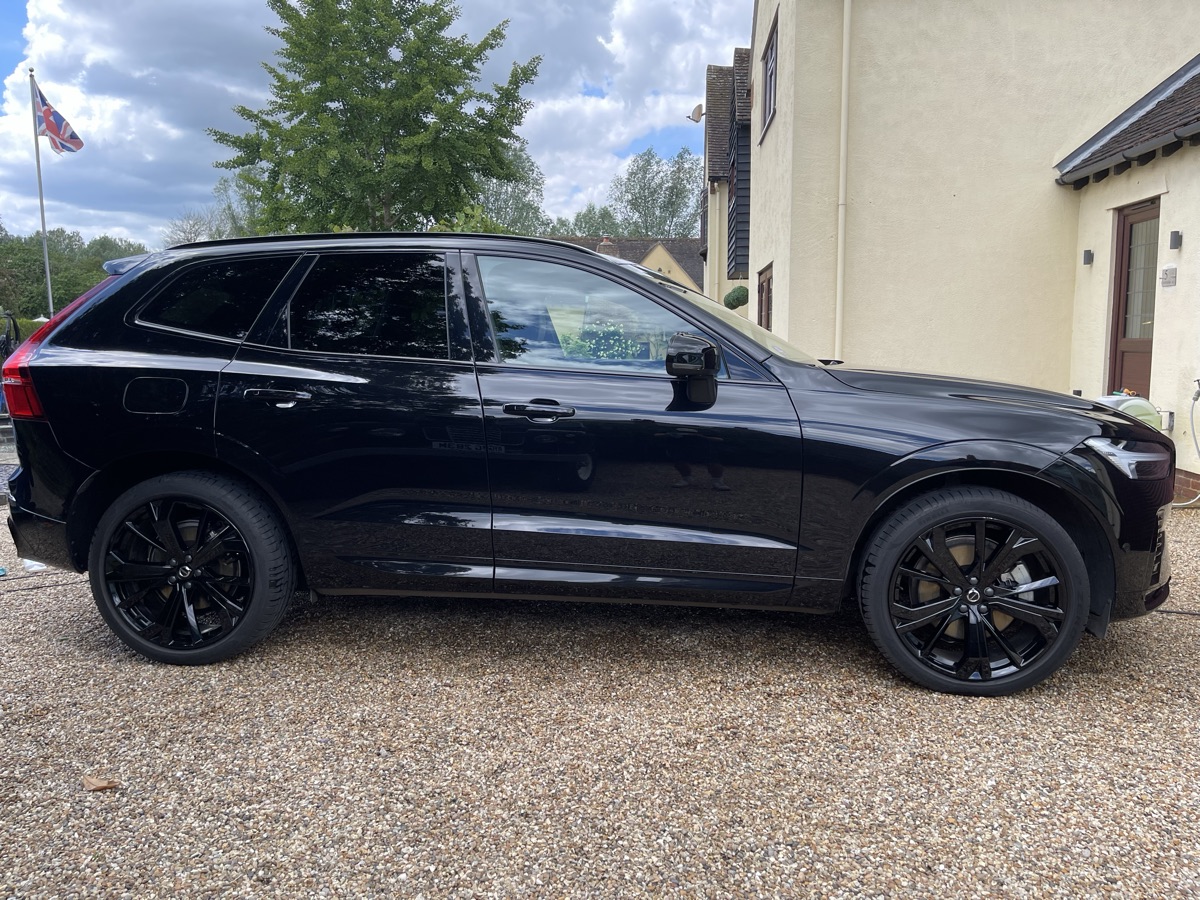 Glossy black Volvo SUV side profile after an exterior clean